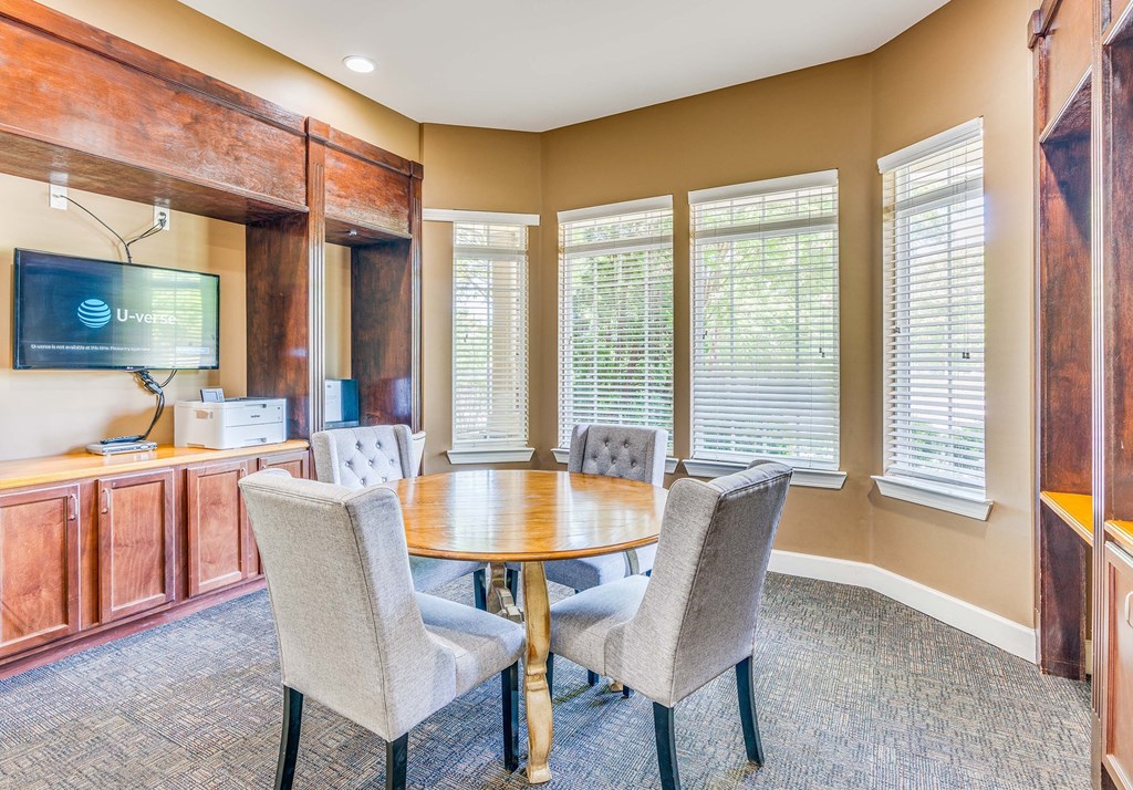 a conference room with a table and chairs and a television