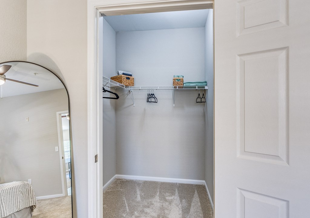 an empty closet with white walls and a white door