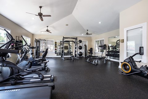 A spacious gym with a variety of equipment including treadmills, elliptical machines, and weights.