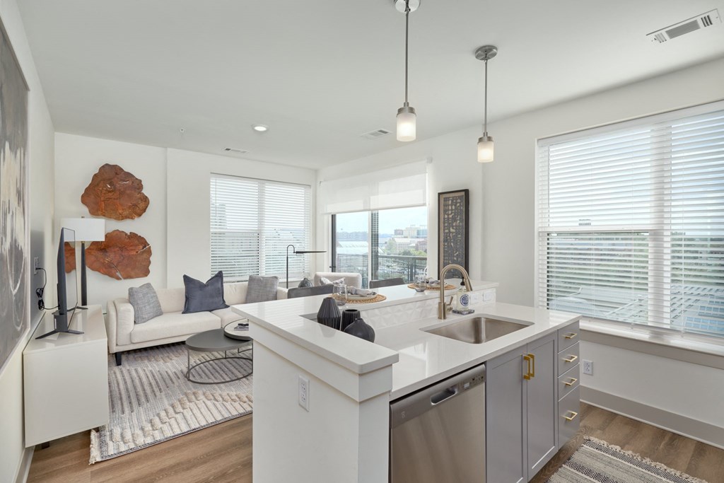 an open kitchen and living room with a large window and a sink