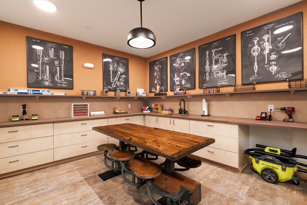 a large classroom with a wooden table and stools