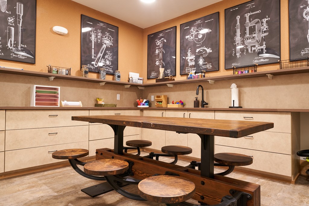 the tasting room has a large wooden table with four stools and a row of
