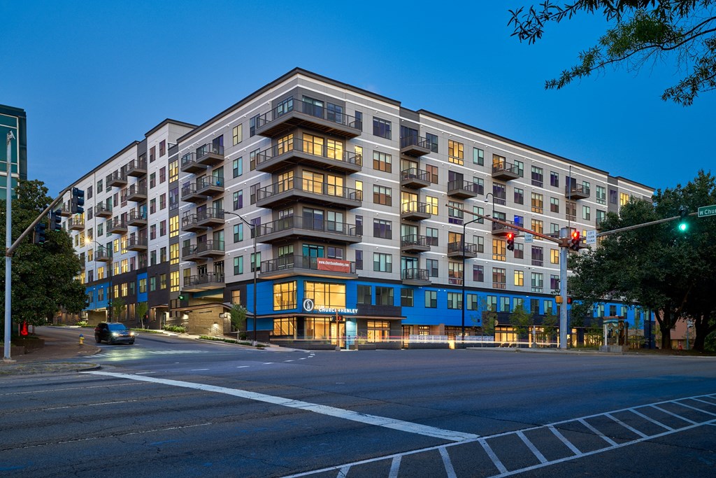 a large apartment building on a city street at night