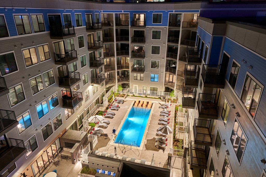 an overhead view of an apartment building with a swimming pool