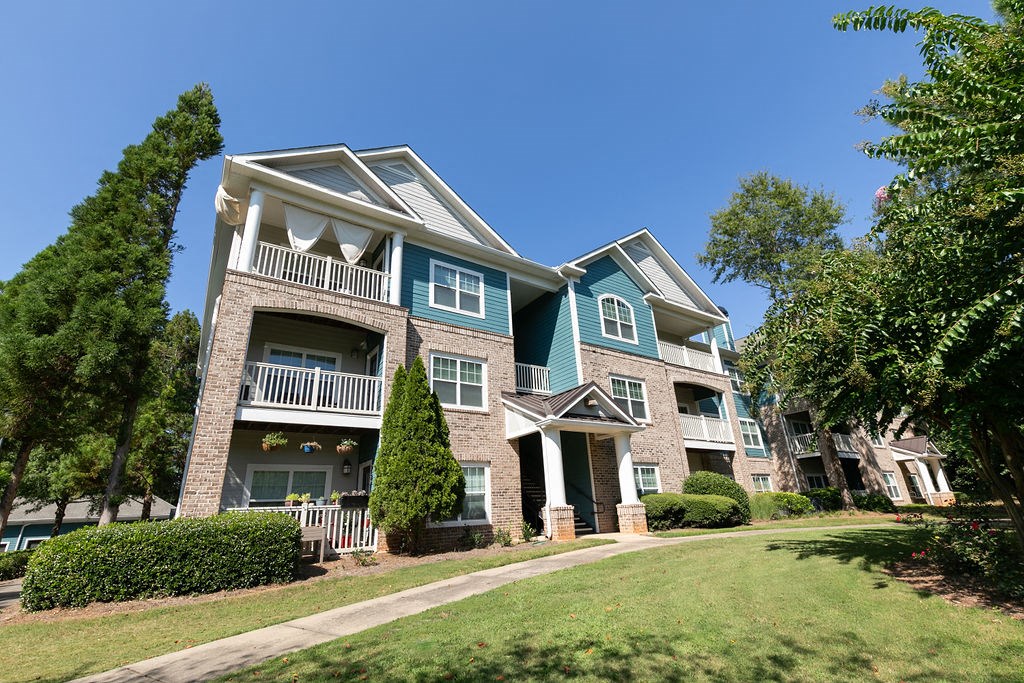 an apartment building with green grass and trees