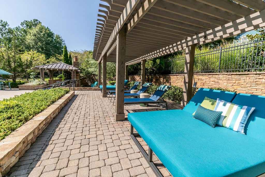 a patio with blue couches and chairs and a pavilion