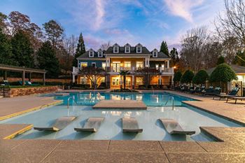 A large house with a pool in front.