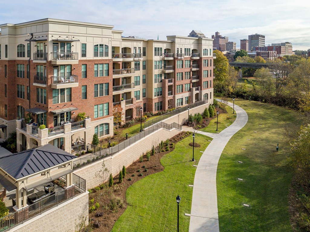 a walkway leading to an apartment building with a city in the background