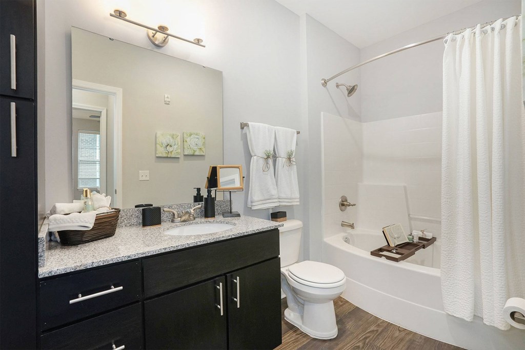 A bathroom with a white tub, sink, and toilet.