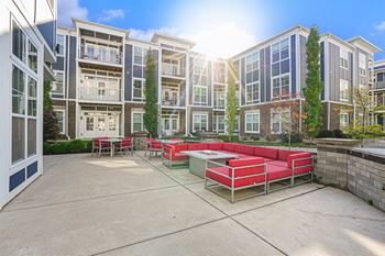 A sunny day at a courtyard with a red and white table and chairs.