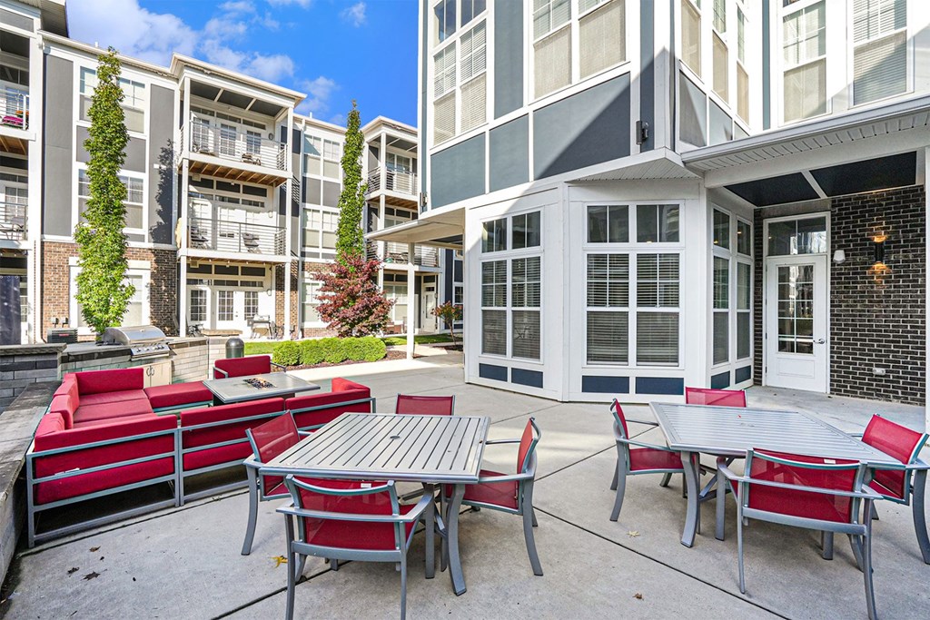 A patio with a table and chairs is surrounded by apartment buildings.