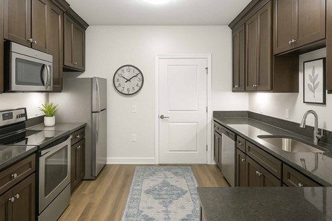 A kitchen with brown cabinets and a white door.