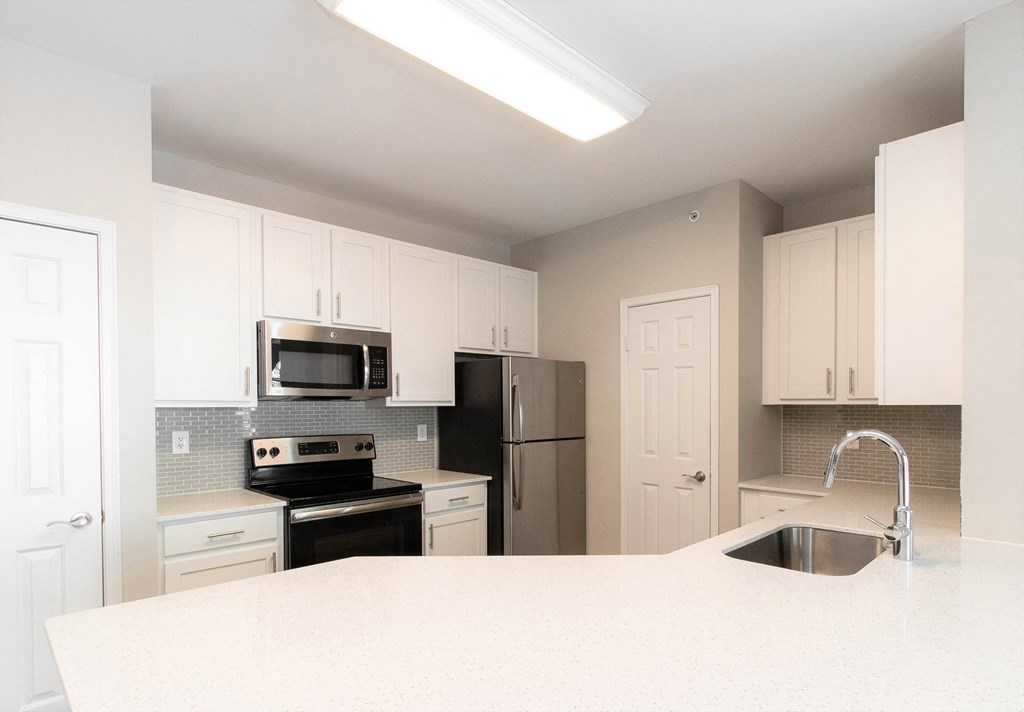 a kitchen with white cabinets and a white counter top