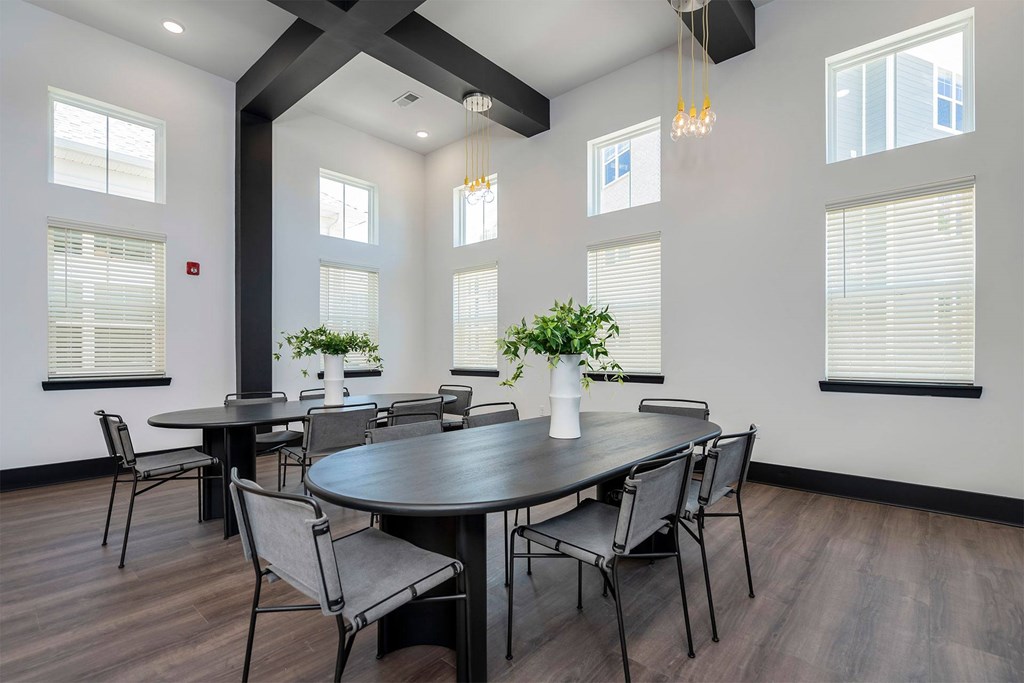 A dining room with a large table and chairs.