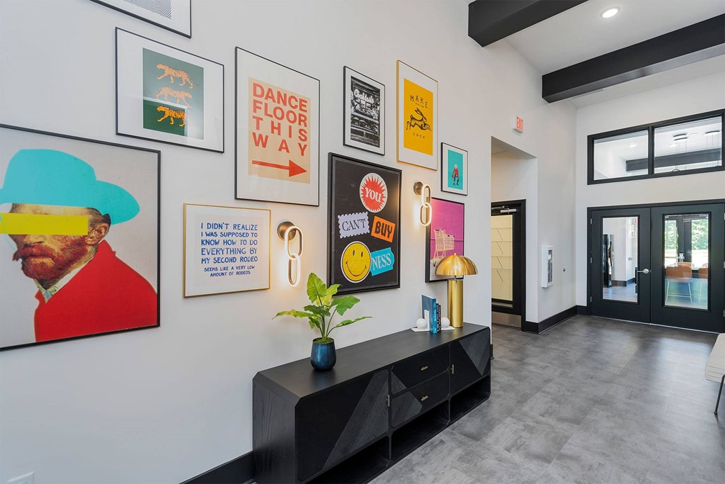 A hallway with a black bench and pictures on the wall.