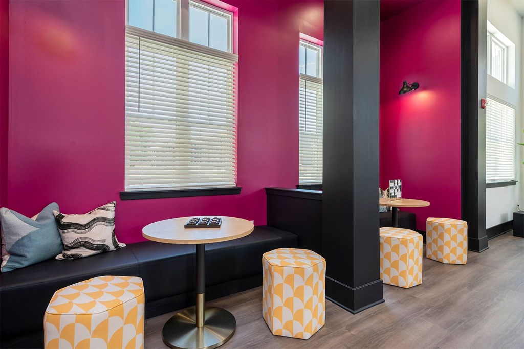 A room with a pink wall and a black column.