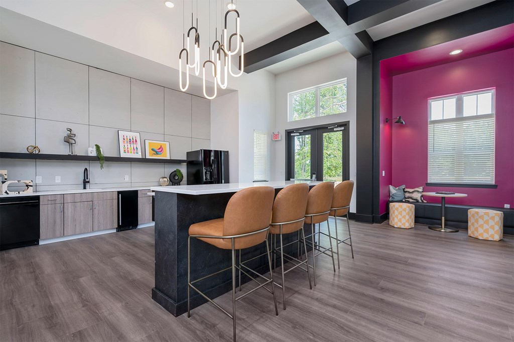 A kitchen with a bar area and chairs.