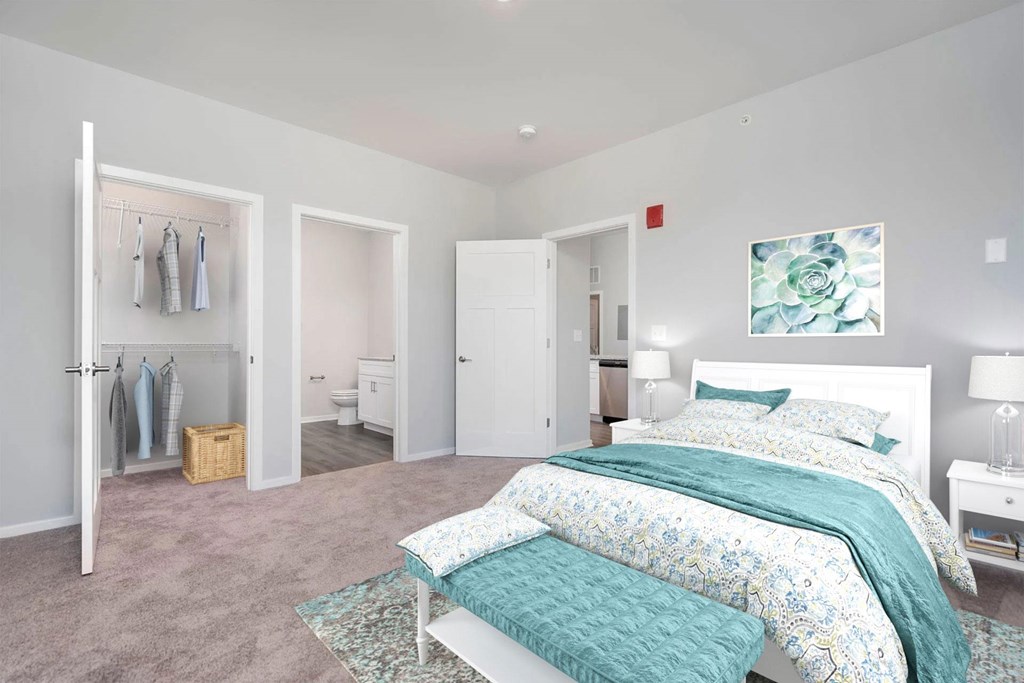 2 Bedroom Luxury Apartments In Jeffersonville, IN - The Laurel - Bedroom With Plush Carpet, Walk-In Closet, Modern Décor, and Attached Bathroom.