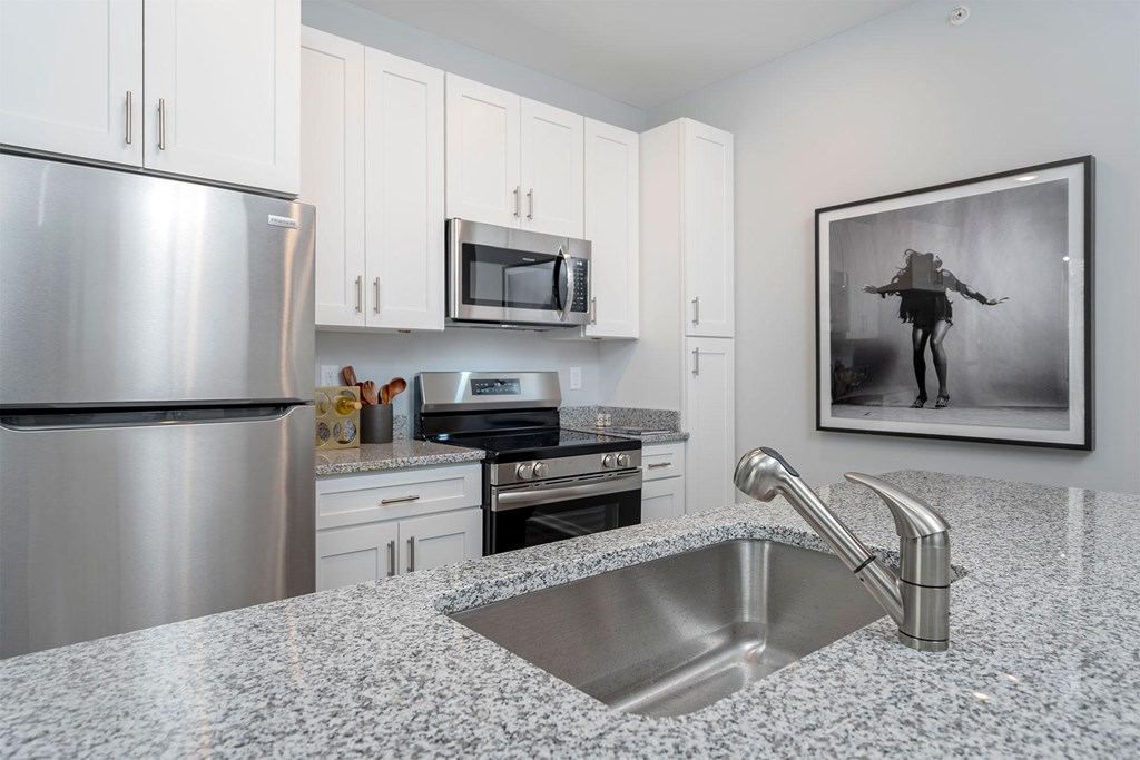 A modern kitchen with granite countertops and stainless steel appliances.