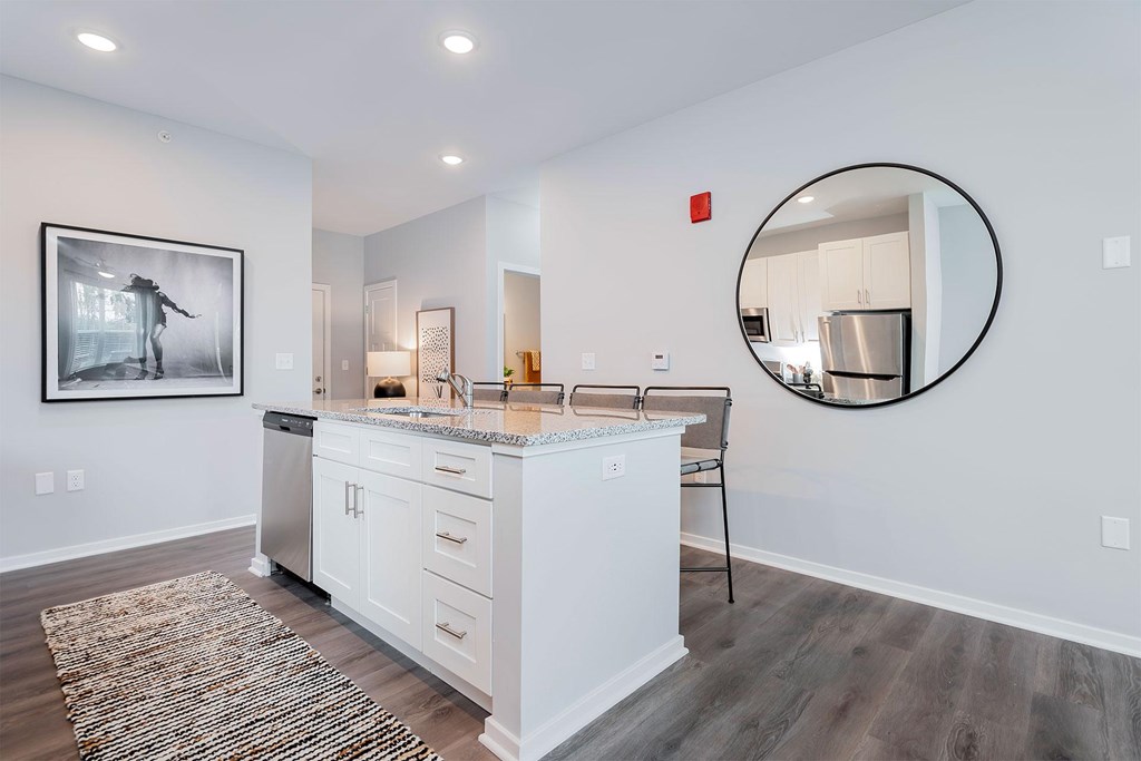A modern kitchen with white cabinets and a large island.