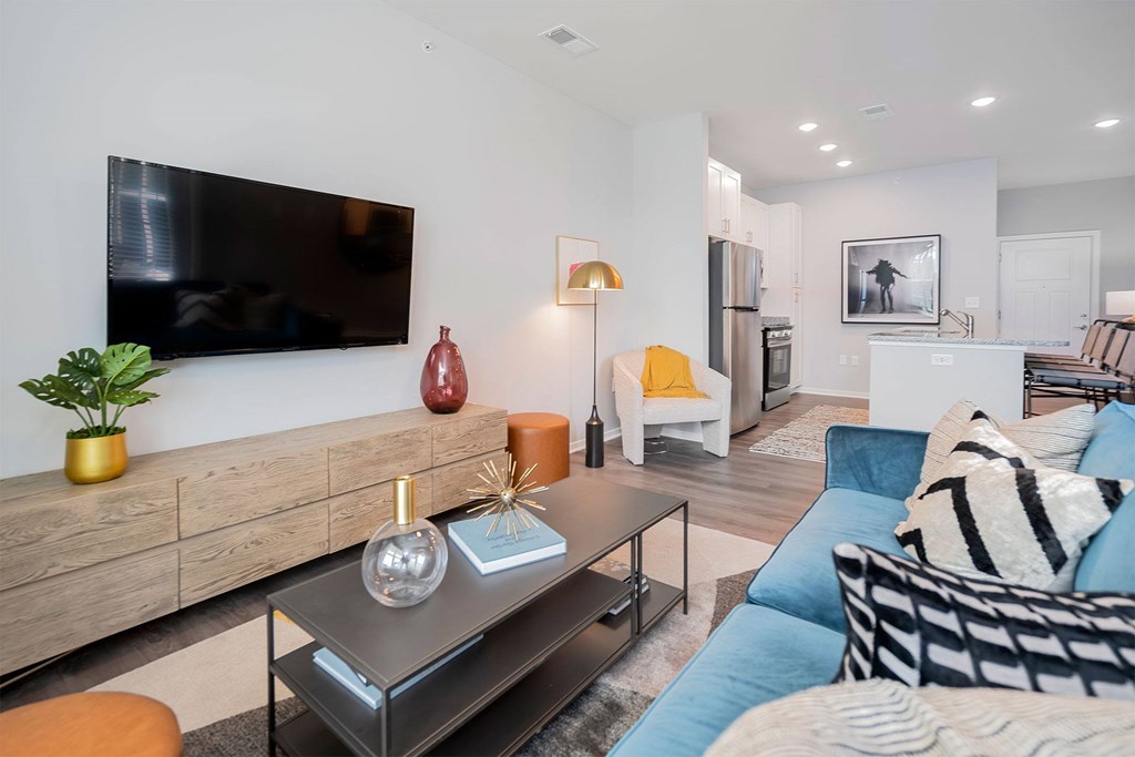 A modern living room with a flat screen TV mounted on the wall.