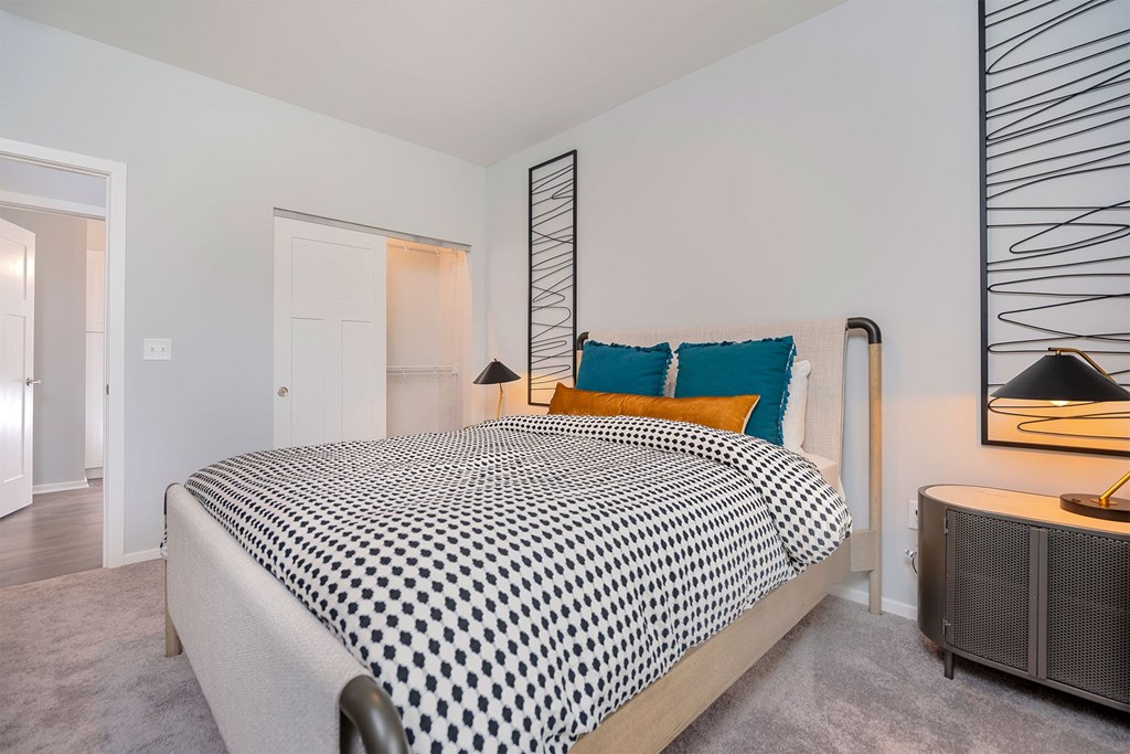 A bedroom with a bed covered in a black and white patterned bedspread.