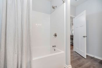 A white bathroom with a shower and a door.