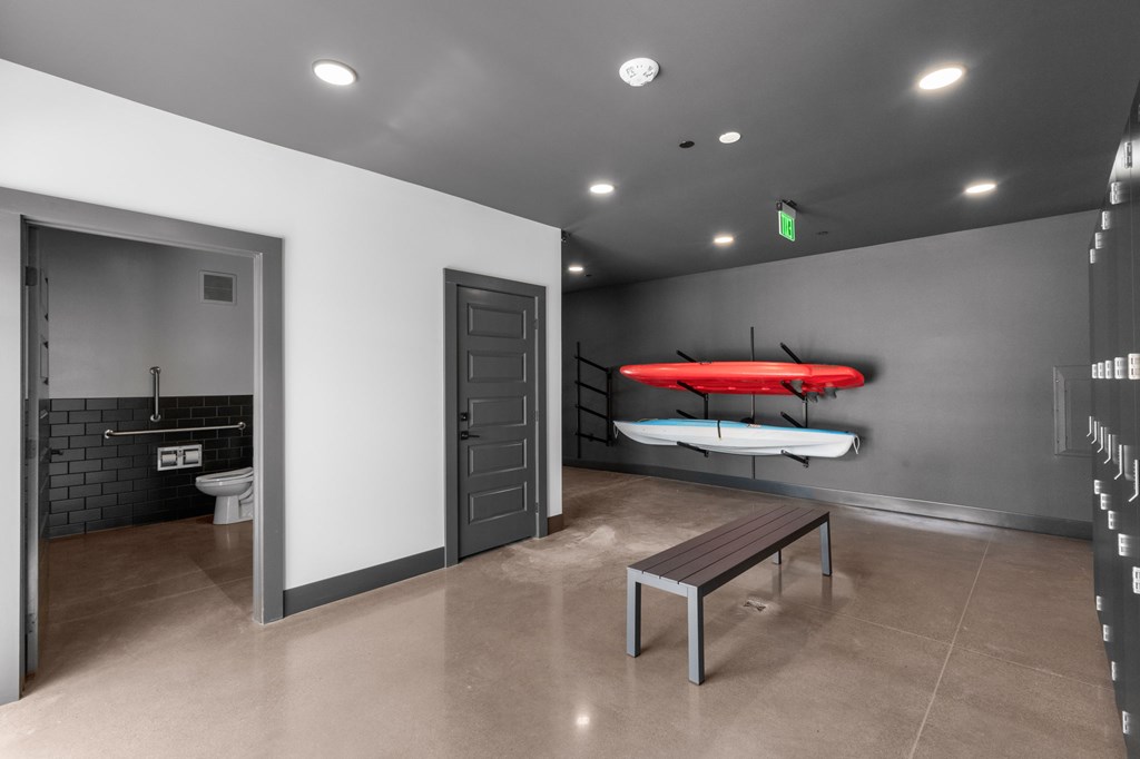 A room with a bench, a surfboard, and a toilet.