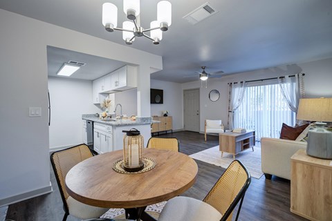 A well-lit dining area with a round wooden table and chairs L'Estancia, Sarasota, FL, 34231