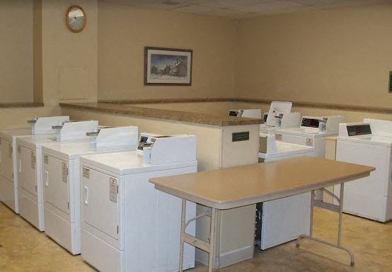 a room filled with white washing machines and a table