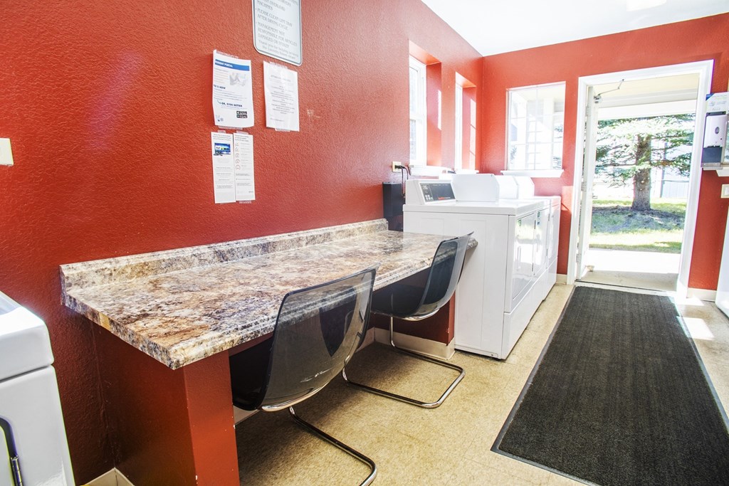 a kitchen with a counter and chairs and a sink