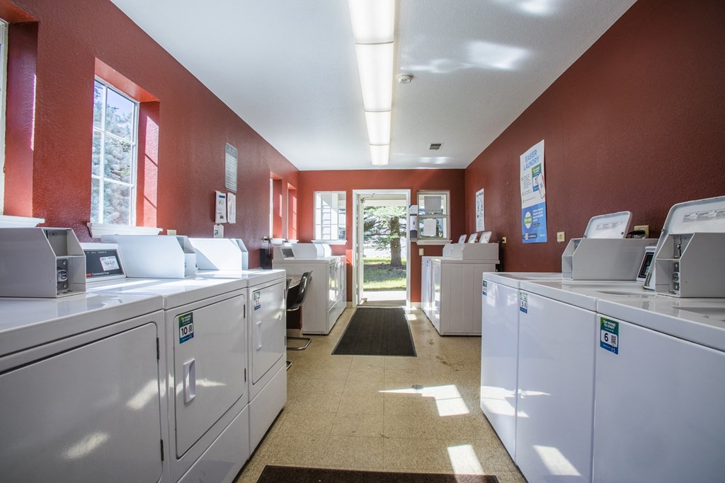a laundry room with washing machines and dryers in it
