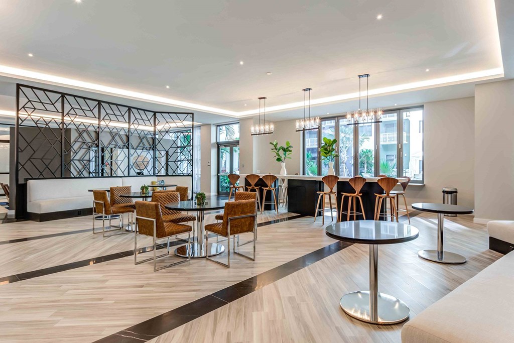 A modern dining area with wooden floors and a mix of round and square tables.