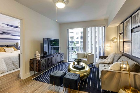 A living room with a black and white striped rug and a gold coffee table.