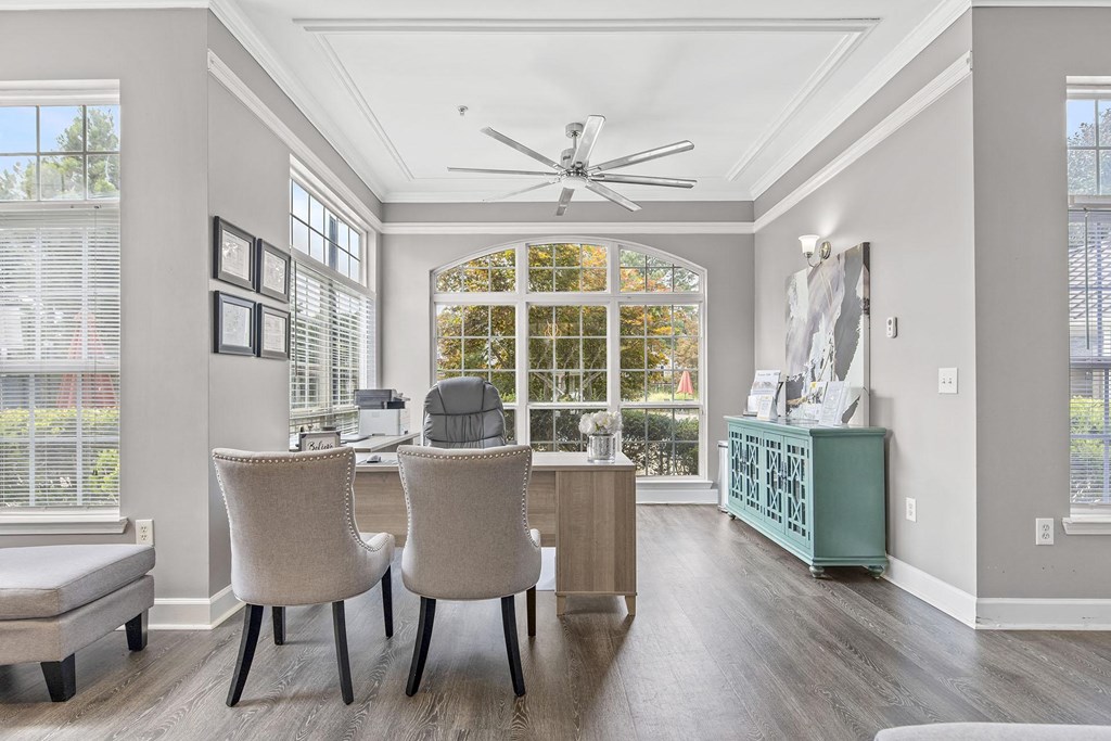 A room with a ceiling fan and a table with chairs.