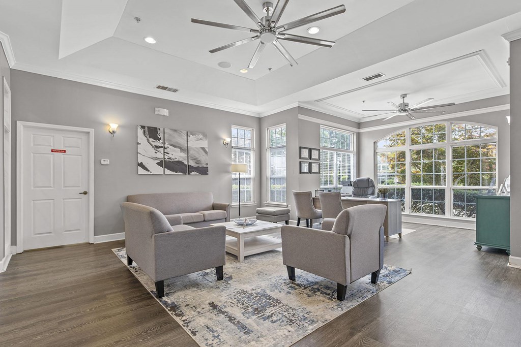 A spacious living room with a grey sofa set and a white coffee table.