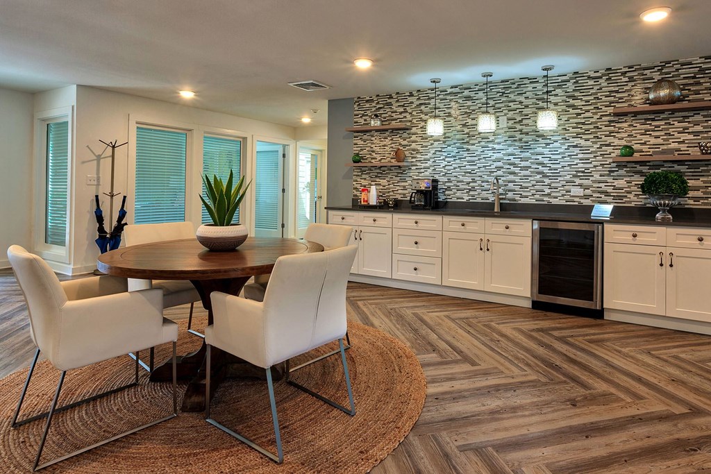 A modern dining room with a stone wall and wooden flooring.