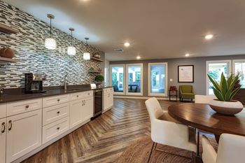 A modern kitchen with a stone wall and wooden floors.