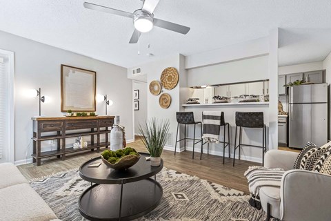 A living room with a black coffee table and a framed picture on the wall.
