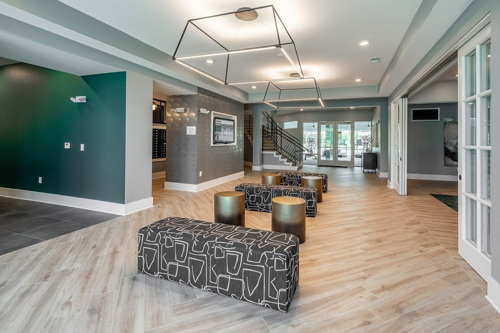 a large lobby with chairs and tables and a staircase