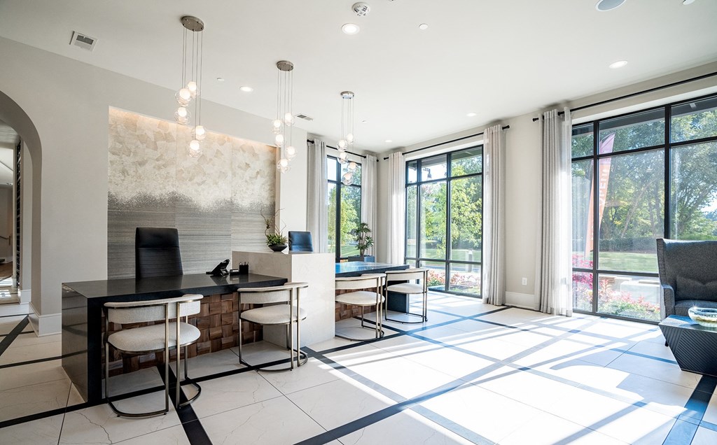 a living room with a desk and chairs and sliding glass doors