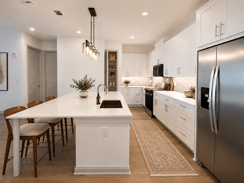 A modern kitchen with a white island and stainless steel appliances.