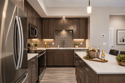 A modern kitchen with dark wood cabinets and a stainless steel refrigerator.
