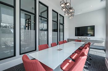 a conference room with a long white table and red chairs at Altis Grand Suncoast, Land O' Lakes, 34638