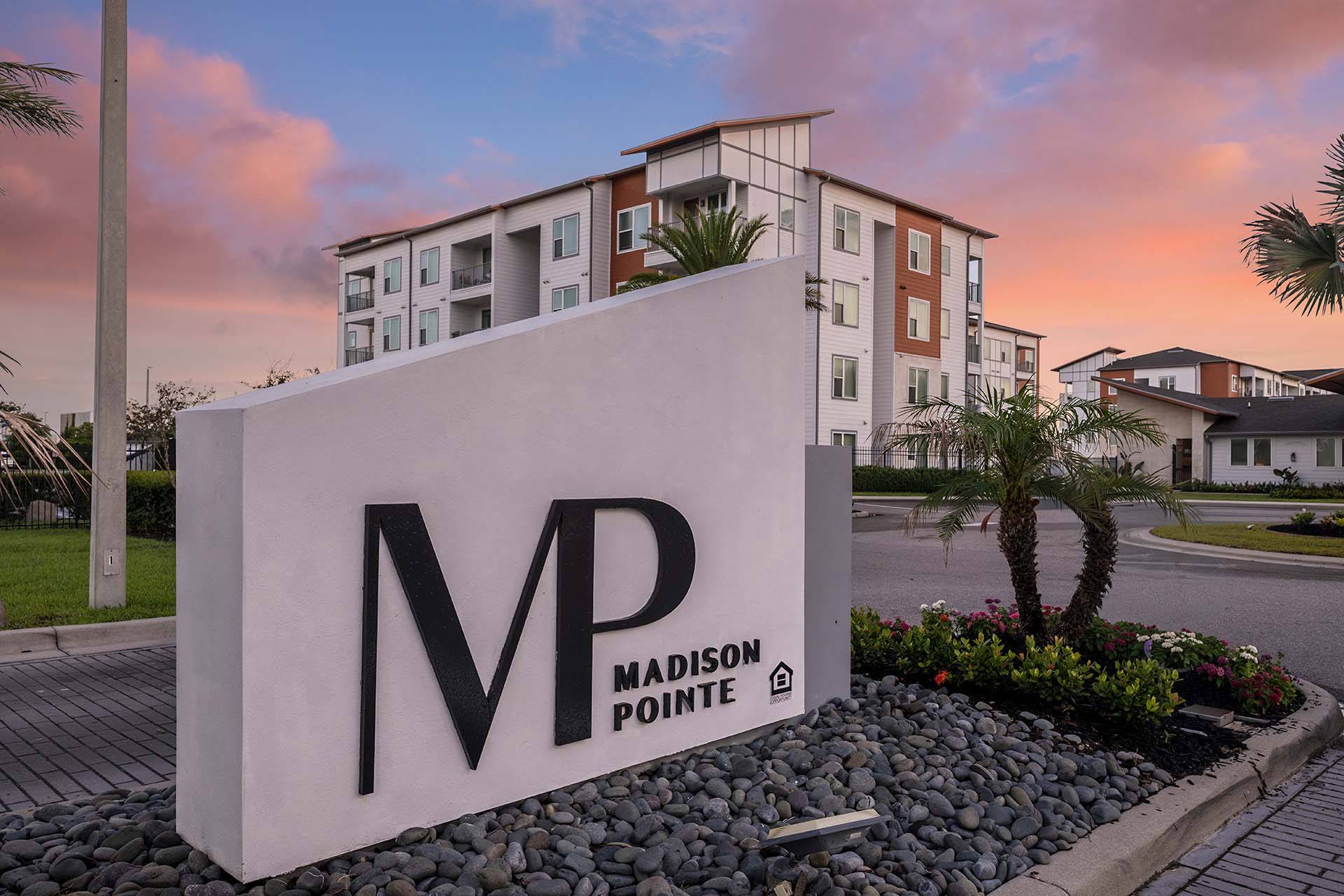 A large white sign with the letters MP on it in front of a building.