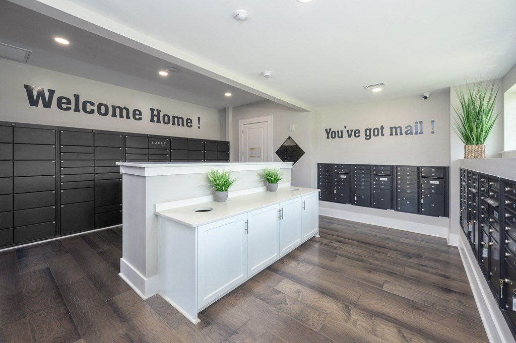 a locker room in a gym with white cabinets and a white counter with two plants