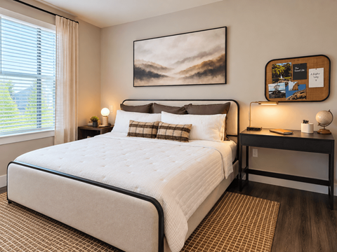 A bedroom with a large bed and a painting on the wall.