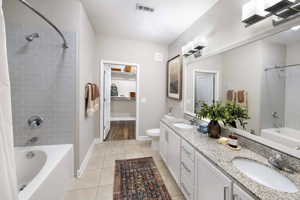 A bathroom with a white tub, sink, and toilet.