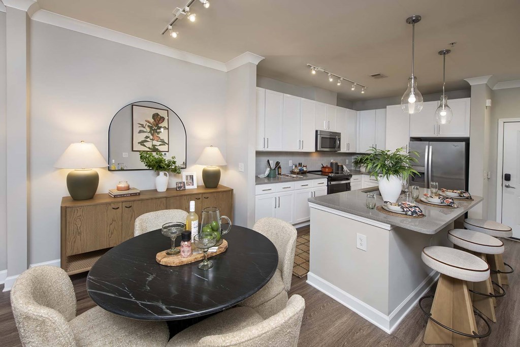 A modern kitchen with a black table and chairs.