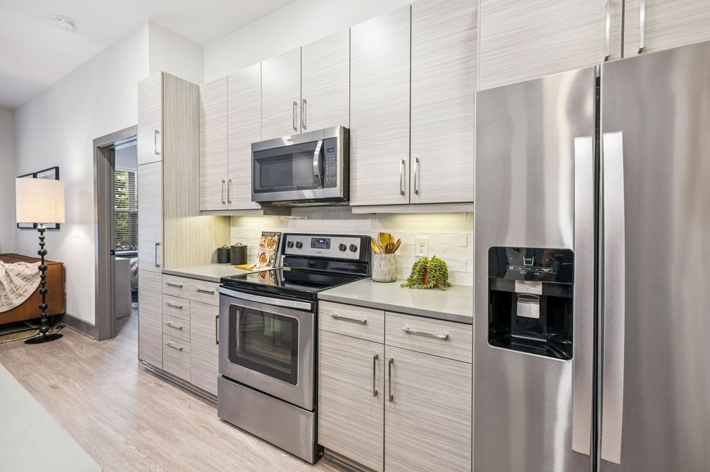 A modern kitchen with stainless steel appliances and white cabinets.